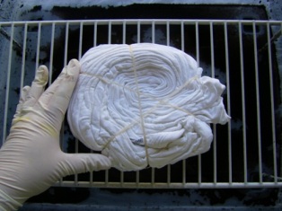 Set dry dipped tied t-shirt onto a rack inside a plastic container.